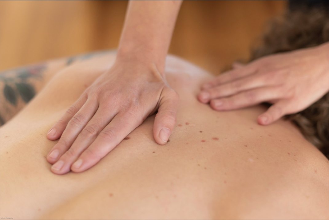 Lisa's hands working along a client's upper back
